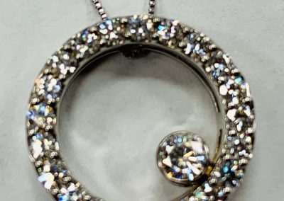 Sparkling diamond pendant necklace with a circular design and chain.