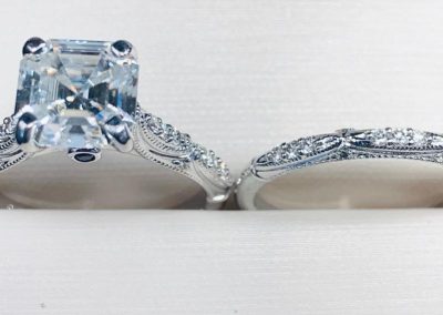 Beautiful diamond engagement ring with intricate band design and matching wedding band.