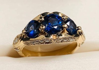 Beautiful gold ring with deep blue sapphires, perfect for custom jewelry designs and repairs.