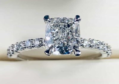 Sparkling diamond ring with a large center stone and pavé band for engagement.