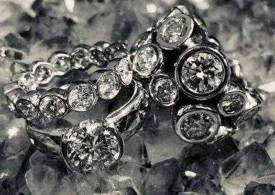 Luxury diamond jewelry including rings and bracelets with sparkling stones.